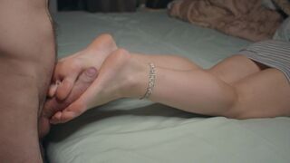 A petite girl is showing her feet and doing a foot job