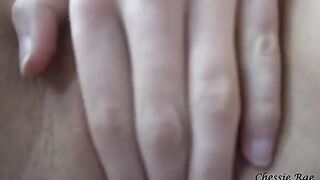 A busty girl, likely Chessie Rae with her iconic 34DD curves, rubs her wet pussy in POV