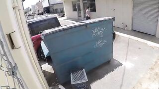 The couple had no idea they were being photographed behind the garbage tank