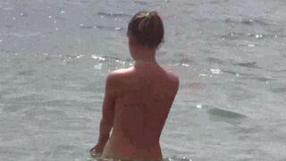 A group of people has fun on a naked beach