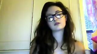 A cute girl in glasses takes off her clothes during a video call