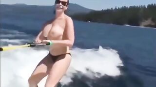 Topless girl skiing on water ski