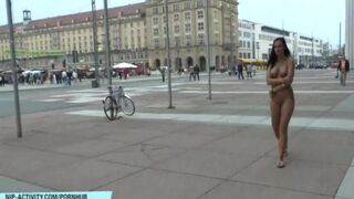 A hot chick is walking the streets of the city naked