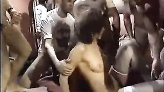 A young whore in stockings is having fun with a group of guys