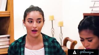 Two hot teens rub their pussies on the couch