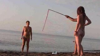 A hot naked girl is having fun on the beach