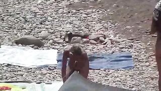 A couple of free-spirited nudists enjoy each other's company on the beach