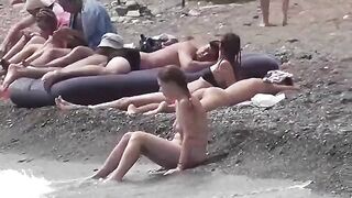 A couple of free-spirited nudists enjoy each other's company on the beach