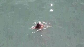 A pair of passionate lovers, naked, enjoy intimate moments at sea