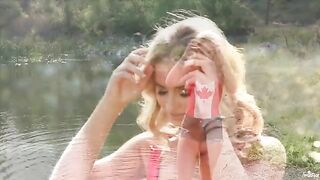 A blondie caresses herself on the shore of a lake in 4K