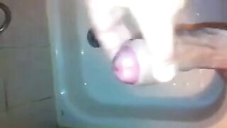 The kid masturbates his dick with his hand while standing in the shower