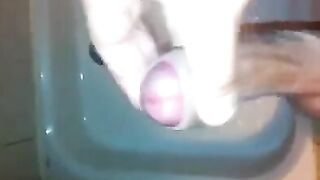 The kid masturbates his dick with his hand while standing in the shower