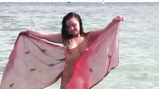 A naked girl bathes in the sea, exposing her body