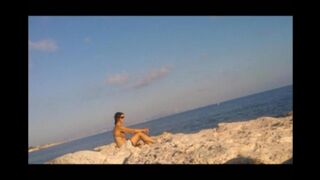 A young girl is basking in sunbathing completely naked