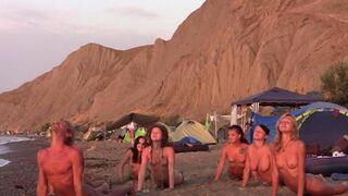A group of girls are having fun playing volleyball naked on the beach