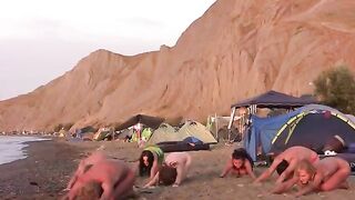 A group of girls are having fun playing volleyball naked on the beach